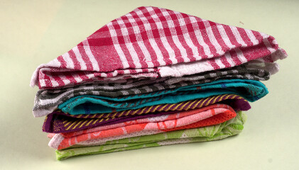 Folded kitchen textile towels of different colors, Household cleaning cloth. Closeup of cleaning rag isolated on a white background.