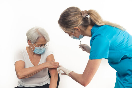Pensioner woman in her 70s gets a vaccine booster. Copy space. White background. High quality photo