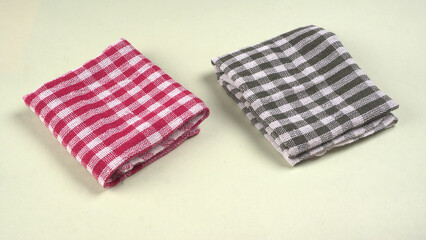 Folded kitchen textile towels of different colors, Household cleaning cloth. Closeup of cleaning rag isolated on a white background.
