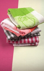 Folded kitchen textile towels of different colors, Household cleaning cloth. Closeup of cleaning rag isolated on a white background.
