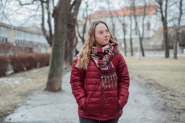 Young woman student with Down syndrome walking in street in winter