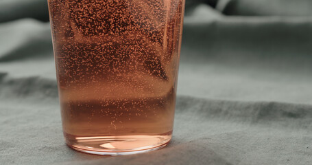pour peach drink into tumbler glass closeup