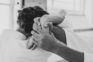 People practicing aikido martial art in a dojo background. Shiho nage technique.