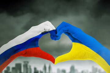 Hands make heart symbol with Russia and Ukraine flag