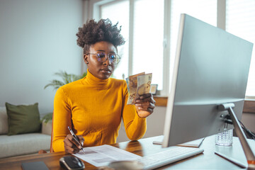 A young African-American girl with glasses in the living room, full of sad restless thoughts, feels tired, trying to survive a month, has rent debts. The concept of crisis and debt