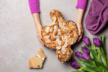 Easter tradition in Italy, Dove Cake topped with icing and almonds.  Colomba di Pasqua. Easter bunny. Spring violet flowers. Top view.