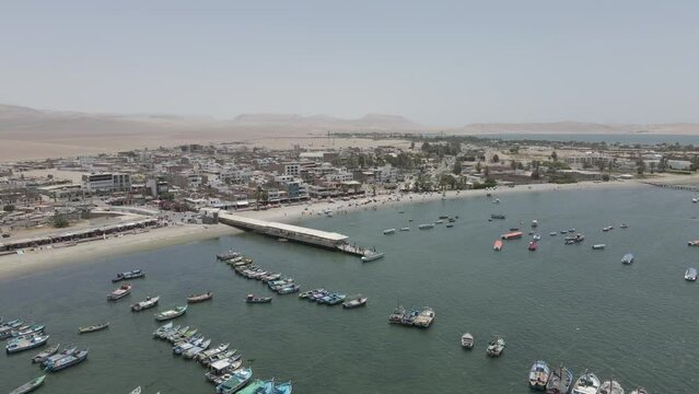 Flight to tourists walking to tour boat on main pier, Paracas Peru