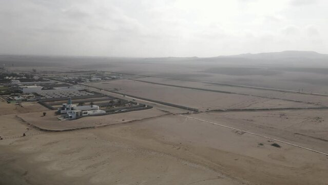 Aerial: Oceanfront home and expansive chala desert at Paracas Peru