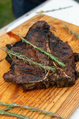 corte de res  T- bone.

T bone 

corte en el asador 

corte al carbón

manos cortando t- bone sobre tabla de madera. 