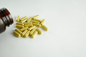 Vitamins for the eyes are yellow in capsules on a white background with a brown bottle
