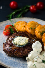 Medium rare grilled beef steak on black background with French fries