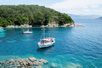 Fototapeta na wymiar Corfu island, Greece, beautiful bay with a boat. Picturesque greek seascape. Yachting, travel, vacations, summer fun, enjoying life and active lifestyle concept