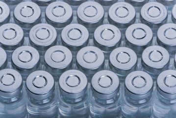 Glass medical ampoule vial for injection. Medicine is dry white drug penicillin powder or liquid with of aqueous solution in ampulla. Close up. Bottles ampule with aluminum cap on backgrounds gray.