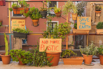 Posters in favor of saving the planet in a garden full of plants. We only have one planet