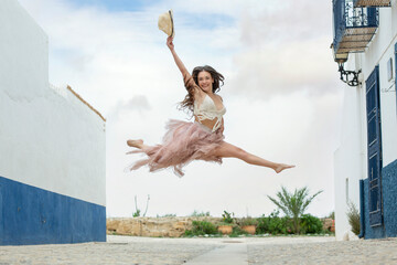 Chica joven divirtiéndose y bailando en la isla de Tabarca en verano