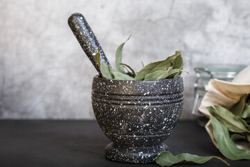 Food background with copy space. Dried bay leaf on the countertop. Mortar and pestle close-up. Grind spices