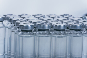 Glass medical ampoule vial for injection. Medicine is dry white drug penicillin powder or liquid with of aqueous solution in ampulla. Close up. Bottles ampule with aluminum cap on backgrounds gray.