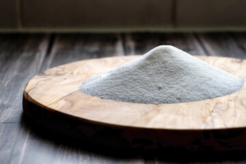 A pile of sugar on a wooden table for home baking