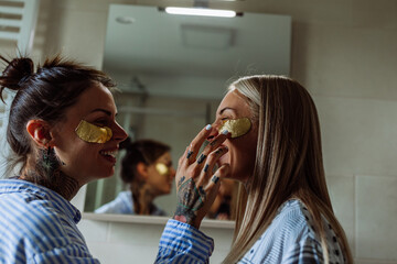 Lesbian couple during skin care in the bathroom