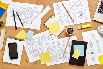 Top view image of web product designers workspace with many website wireframe sketches and sitemap. - obrazy, fototapety, plakaty