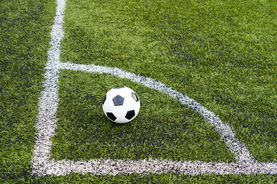 classic pentagonal black and white ball on football or soccer field with artificial grass