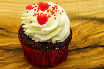 Chocolate cupcake with red heart decoration on wooden with copyspace