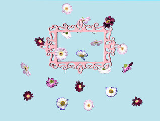 Romantic spring floral concept, vintage pink frame and daisy flowers floating against pastel sky blue background. 