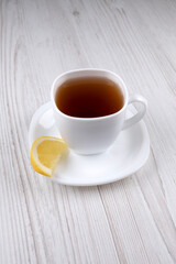 Tea with lemon. Tea in a white cup. A slice of lemon on a white saucer