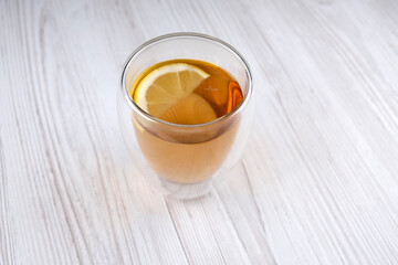 Tea with lemon in a glass cup on a wooden table. Useful drink. Warming drink