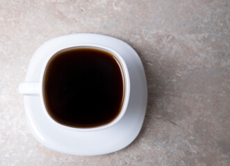 A cup of coffee on a stone table, top view. Drink for the morning