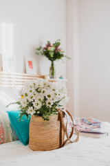 Bouquet of white daisies in a basket on a bed