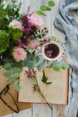 Overhead cup of tea with flowers and books