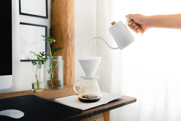 Drip coffee,Pouring a hot water over a drip coffee on the table