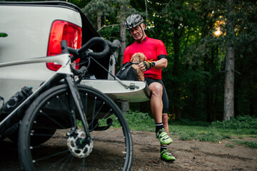 Man is on bike tour through forest with his puppy