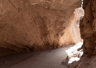 Hiking through the narrow desert trails of the Quebrada de Chulakao (aka., Devil’s Throat). Dramatic sand, dunes and rock formations. San Pedro de Atacama, Cordillera de la Sal. Chile © Luis