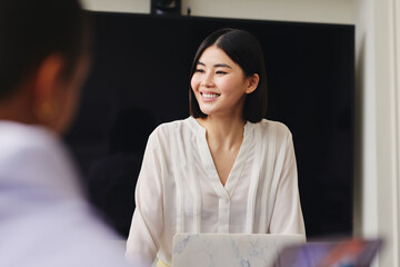 Portrait of cheerful mid adult Chinese businesswoman smiling in business meeting with confident...