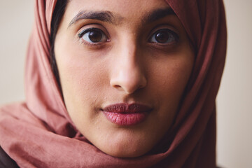 Portrait of young Muslim woman wearing hijab looking towards camera with pensive expression