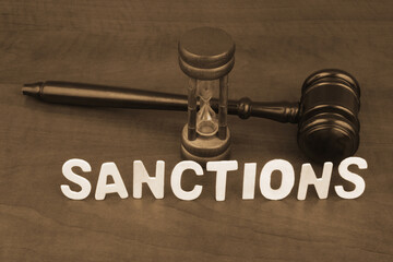 Word  sanctions and judge gavel with hourglass.