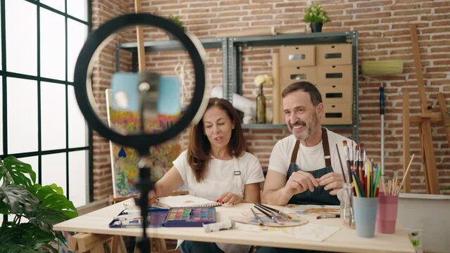 Man and woman artist couple recording draw tutorial at art studio