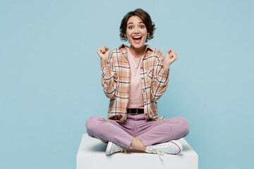 Full body young smiling cheerful happy woman 20s wear casual brown shirt sit on white chair do...