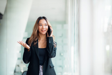 Talking on the phone, Portrait of middle-aged Asian woman using a mobile phone and making a call...