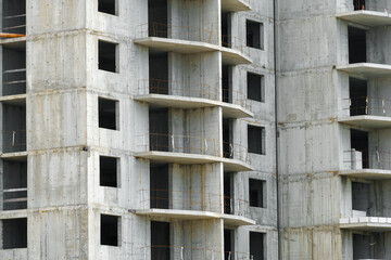 construction of a modern high-rise building, the creation of a concrete frame, building materials and a construction crane