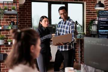 Cyber security agency employees using laptop to monitoring internet bandwidth and database used storage. Software developers analyzing received encrypted files by scanning them for malware.