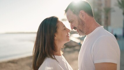 Man and woman couple standing together and kissing at seaside