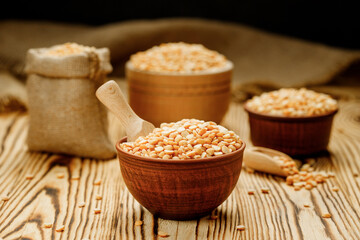 Pea groats in bowls and bags on a wooden background. High quality photo