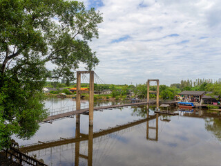 the old-style bridge, beautiful river, and green trees, Thailand.