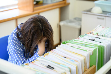 残業が大変で職員室で悩む先生