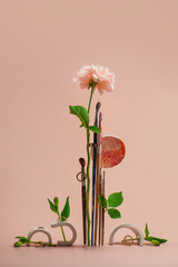 Ikebana with paintbrushes, flowers and golden rings, wedding invitation card, pink background