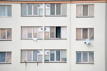 Architectural details of modern high apartment building facade with many windows and balconies