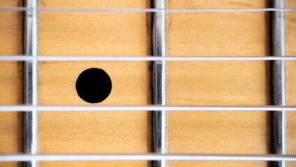 Stringed instrument music background, macro detail of metal chords on electric guitar wooden...